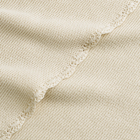 Cotton Knit Baby Blanket in Ivory. Close up shot to see soft woven texture and trim detail.