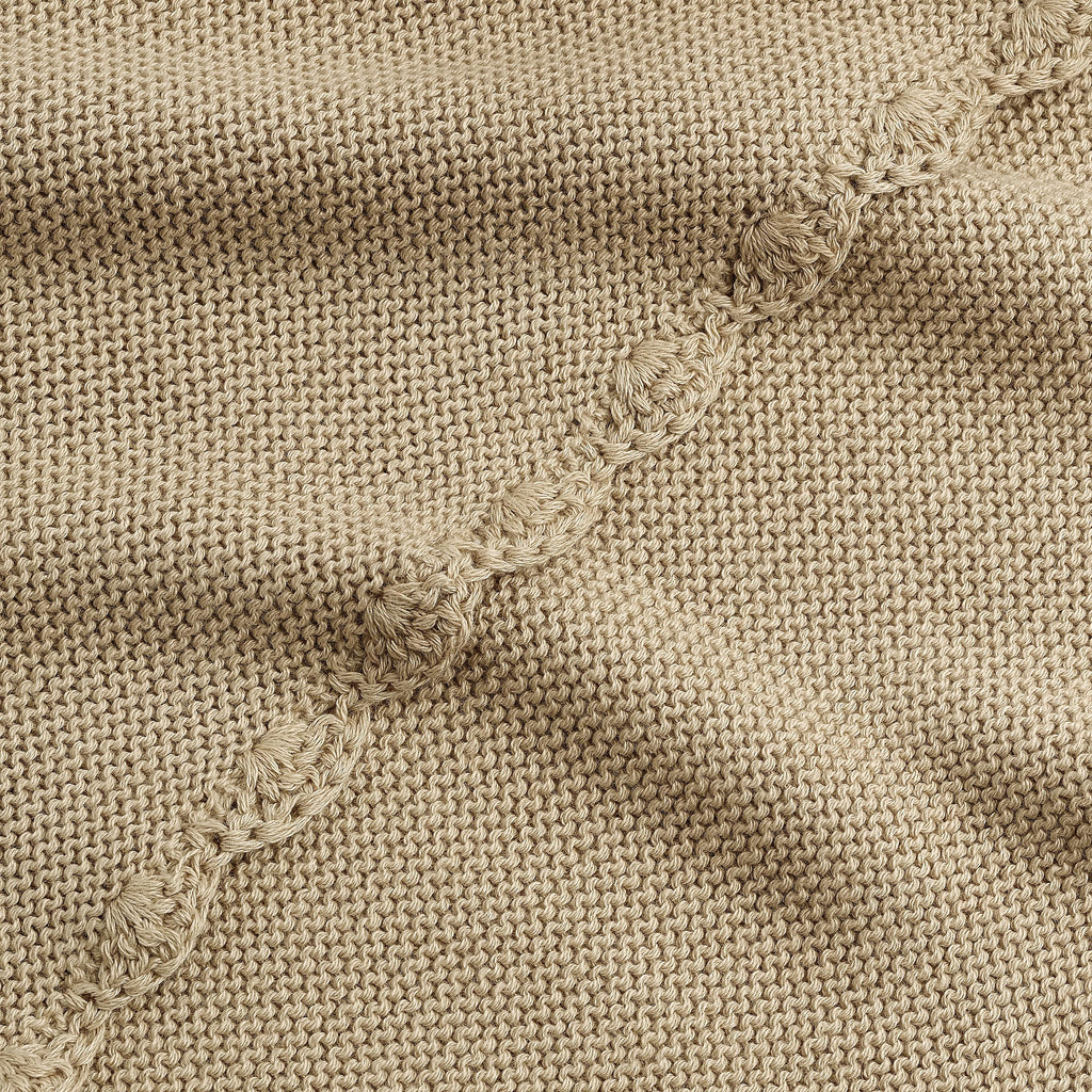 Cotton Knit Baby Blanket in Beige. Close up shot to see soft woven texture and trim detail.