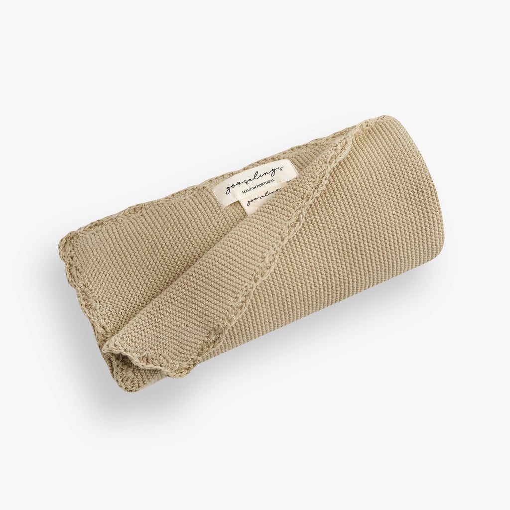 Personalize Me: Cotton Knit Baby Blanket in Beige rolled up. The Gooselings label is shown for detail