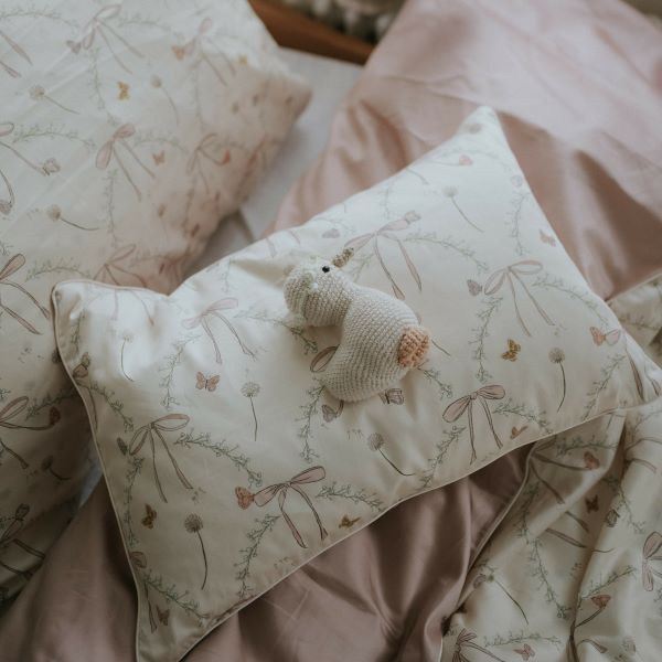 Bows & Butterfly Kisses Toddler Pillow in Pink. Goosie stuffy laying on top.