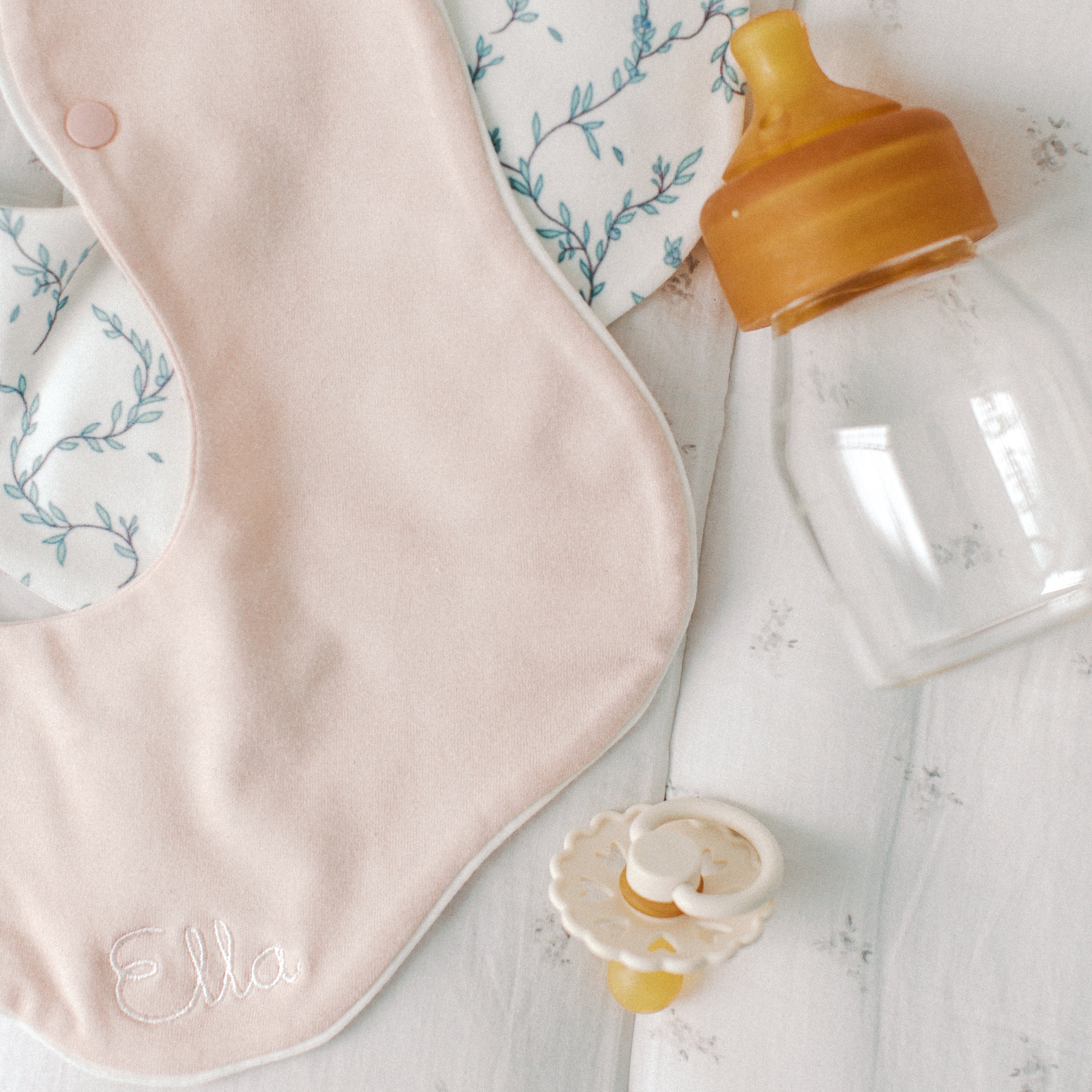 burp cloth in pink with glass bottle and pacifier